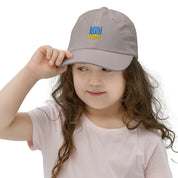 Youth wearing grey baseball cap with Ukrainian Tryzub, breathable and adjustable, made from soft bio-washed chino cotton twill.