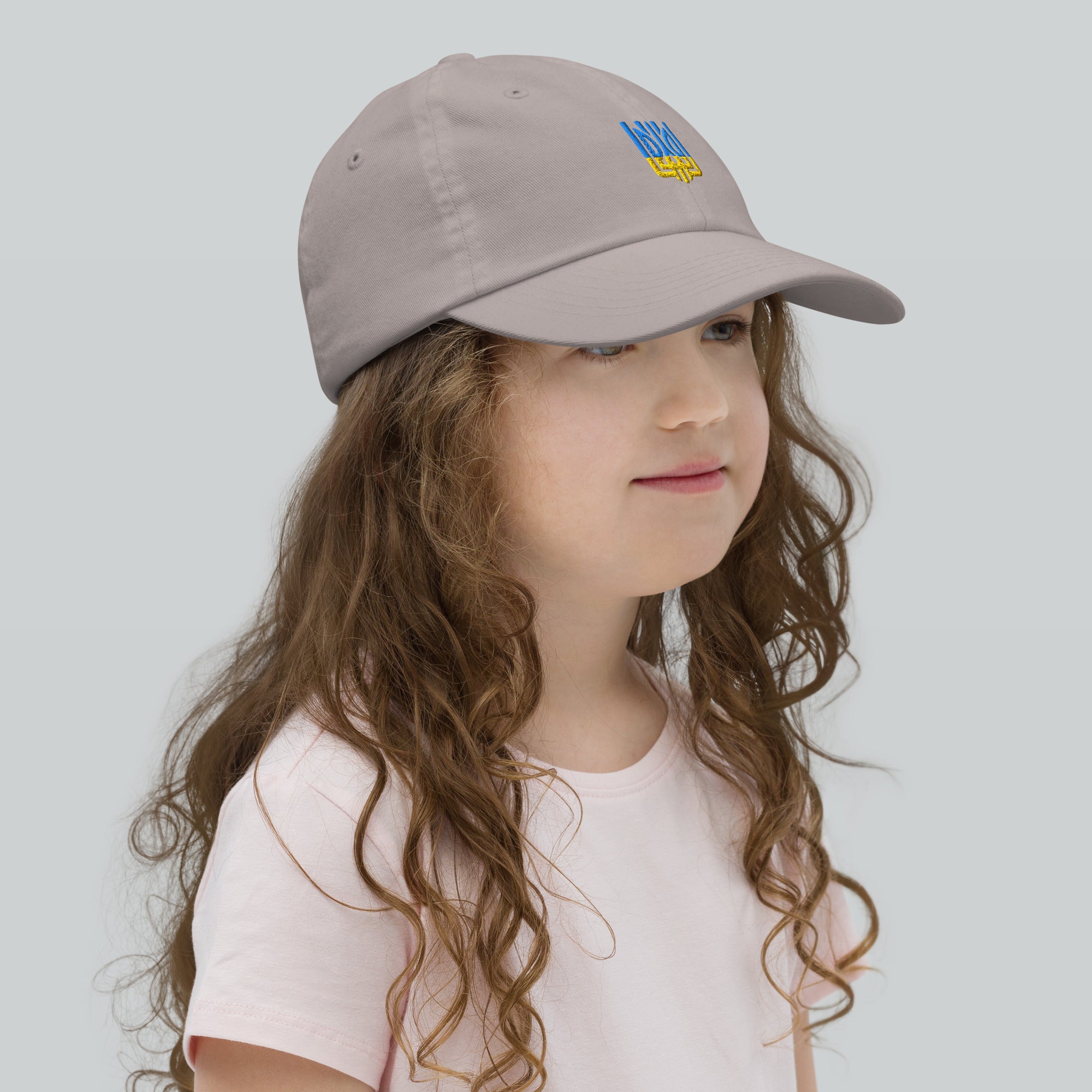 Child wearing gray baseball cap with Ukrainian Tryzub emblem, ideal for outdoor activities and everyday wear.