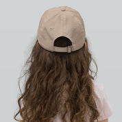 Child wearing beige youth baseball cap with adjustable strap for a secure fit. Ideal for active kids' outdoor adventures.