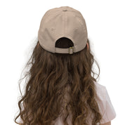 Back view of youth wearing adjustable beige baseball cap with buckle, showcasing breathable design and comfort for kids.