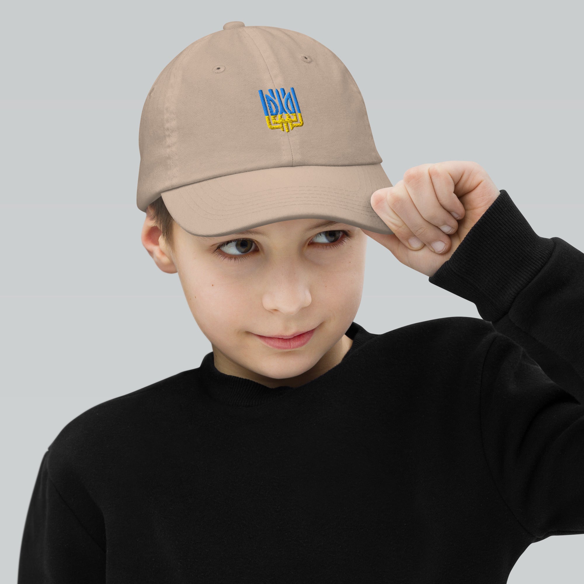 Youth wearing a breathable baseball cap with a Ukrainian Tryzub emblem, ideal for active kids and outdoor adventures.