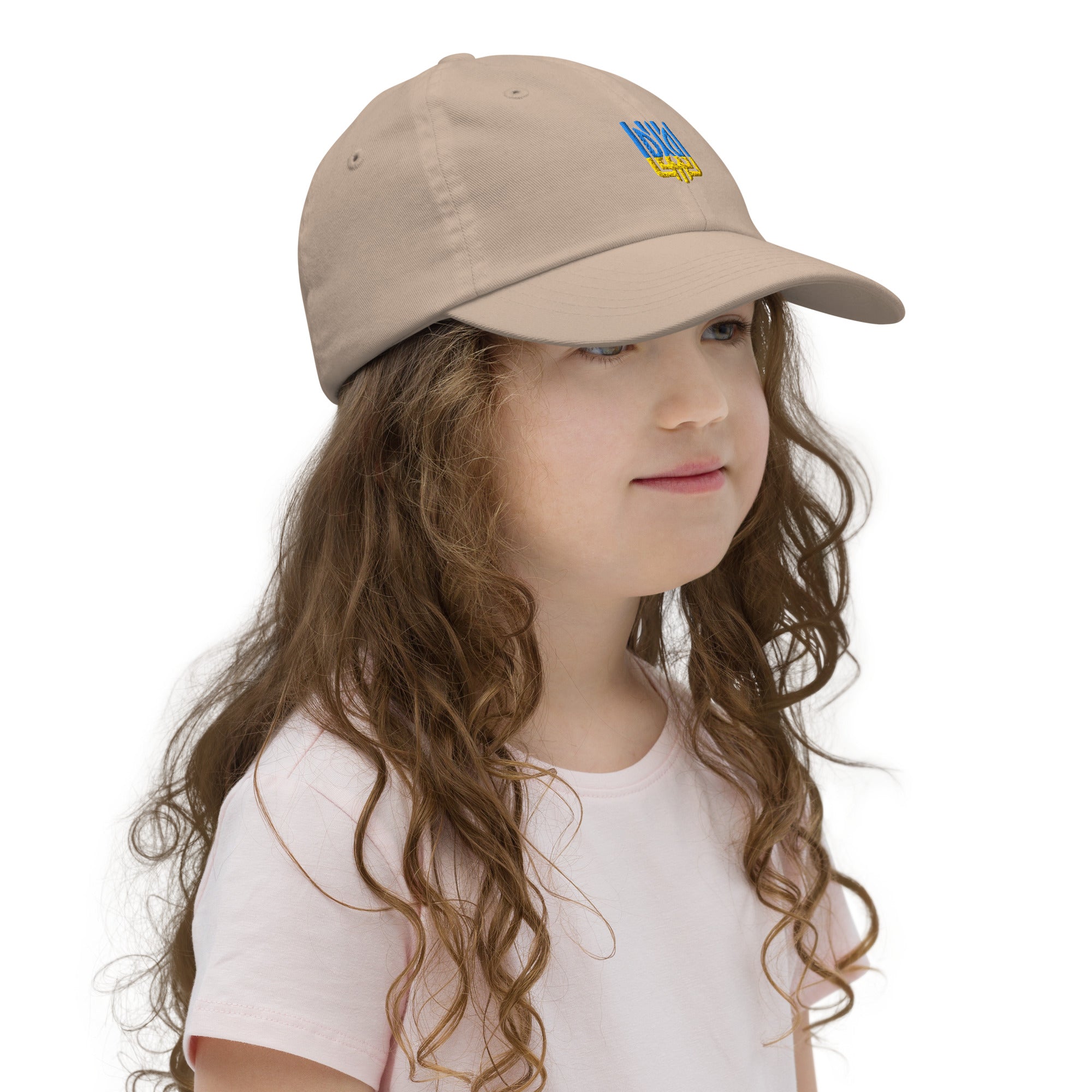 Girl wearing youth baseball cap with Ukrainian Tryzub, breathable and adjustable for active kids, made from bio-washed chino cotton twill.