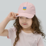 Young girl wearing a pink youth baseball cap featuring Ukrainian Tryzub emblem, ideal for outdoor activities and sports, with adjustable strap.