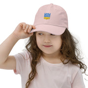 Child wearing a pink youth baseball cap with Ukrainian Tryzub emblem, ideal for sports and outdoor activities, made of soft cotton twill.