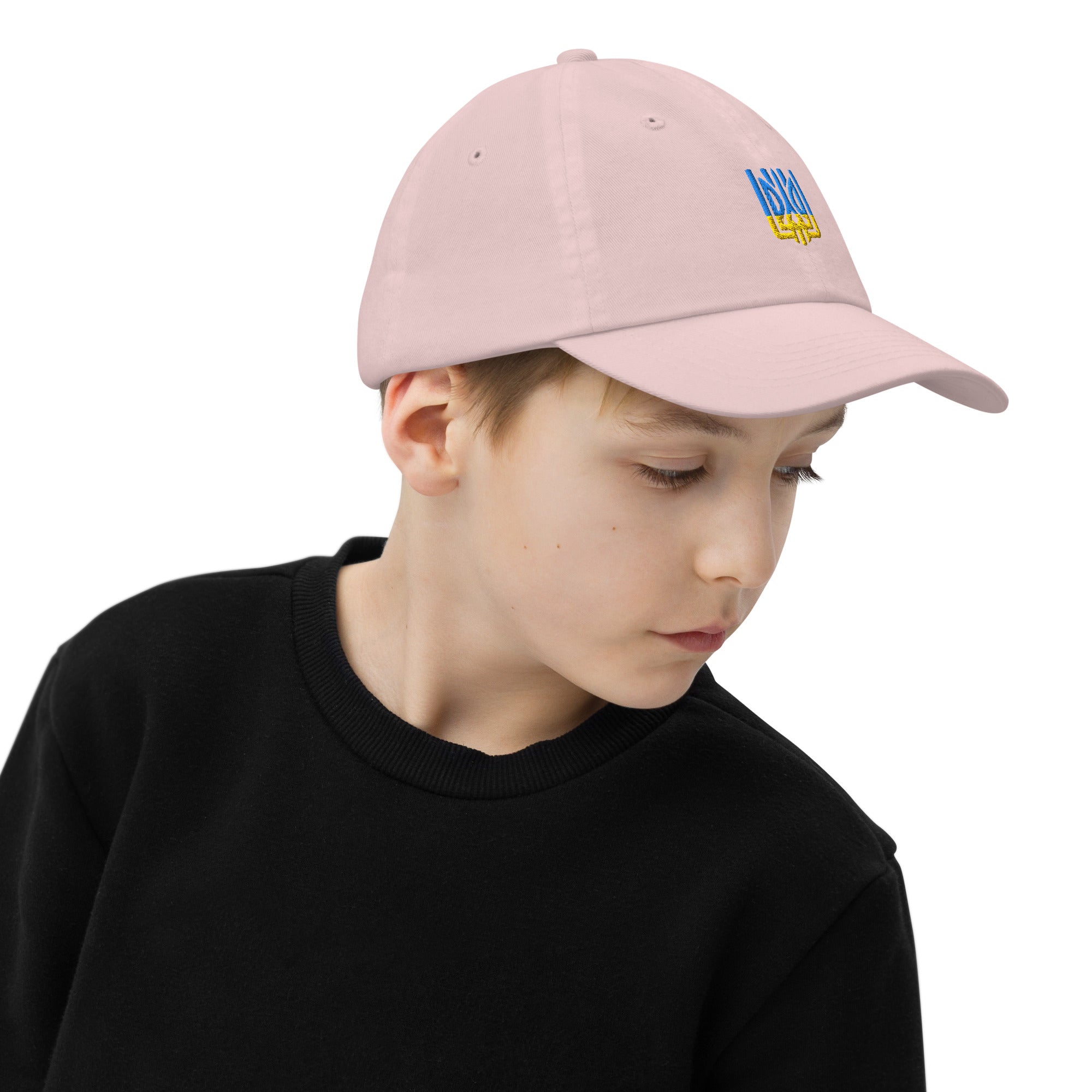 Youth wearing pink baseball cap with Ukrainian Tryzub emblem, featuring breathable design and adjustable strap for active kids.