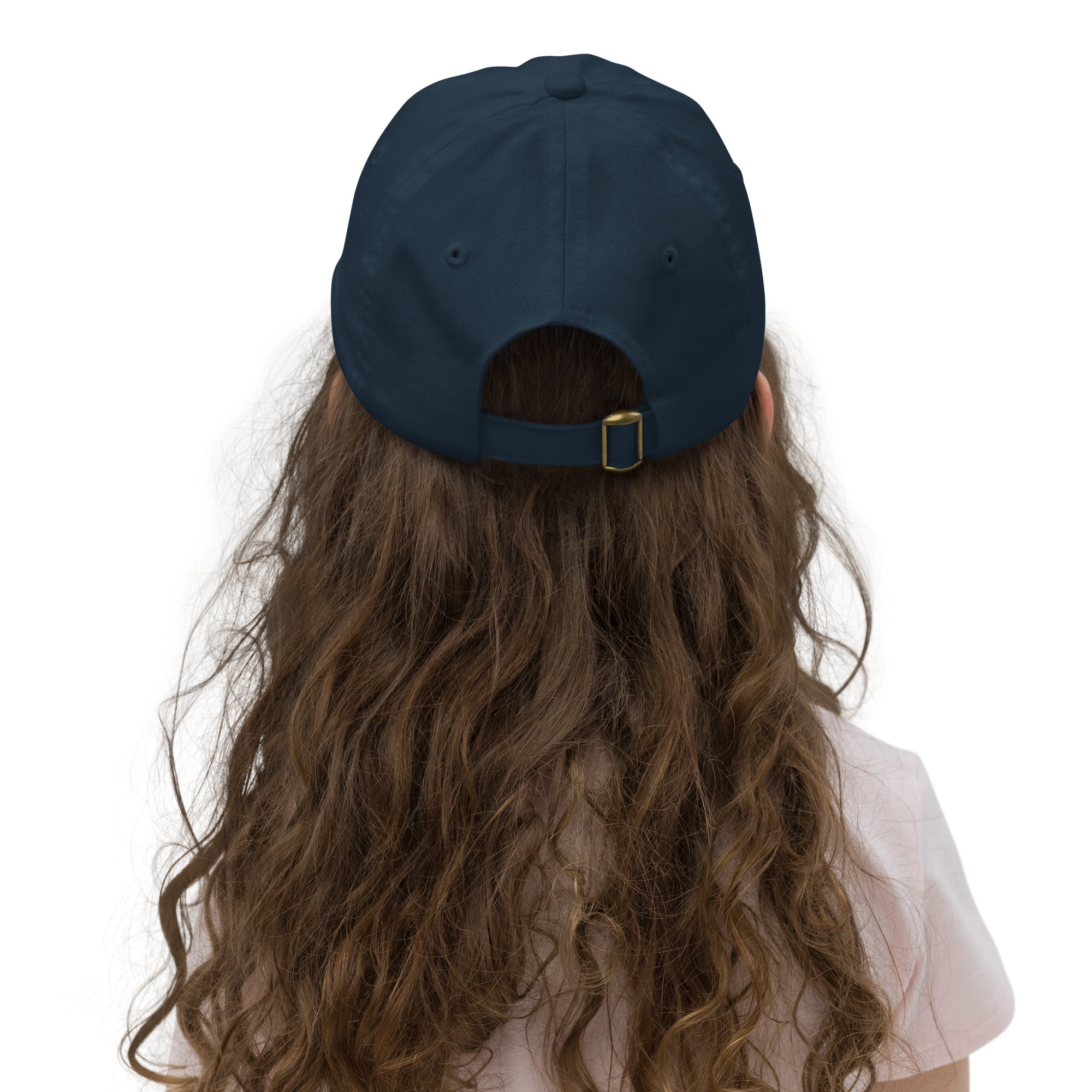 Back view of a child wearing a navy blue adjustable baseball cap with Ukrainian Tryzub, showcasing long hair and casual attire.