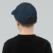 Child wearing youth baseball cap with adjustable strap and eyelets for ventilation, featuring Ukrainian Tryzub emblem.