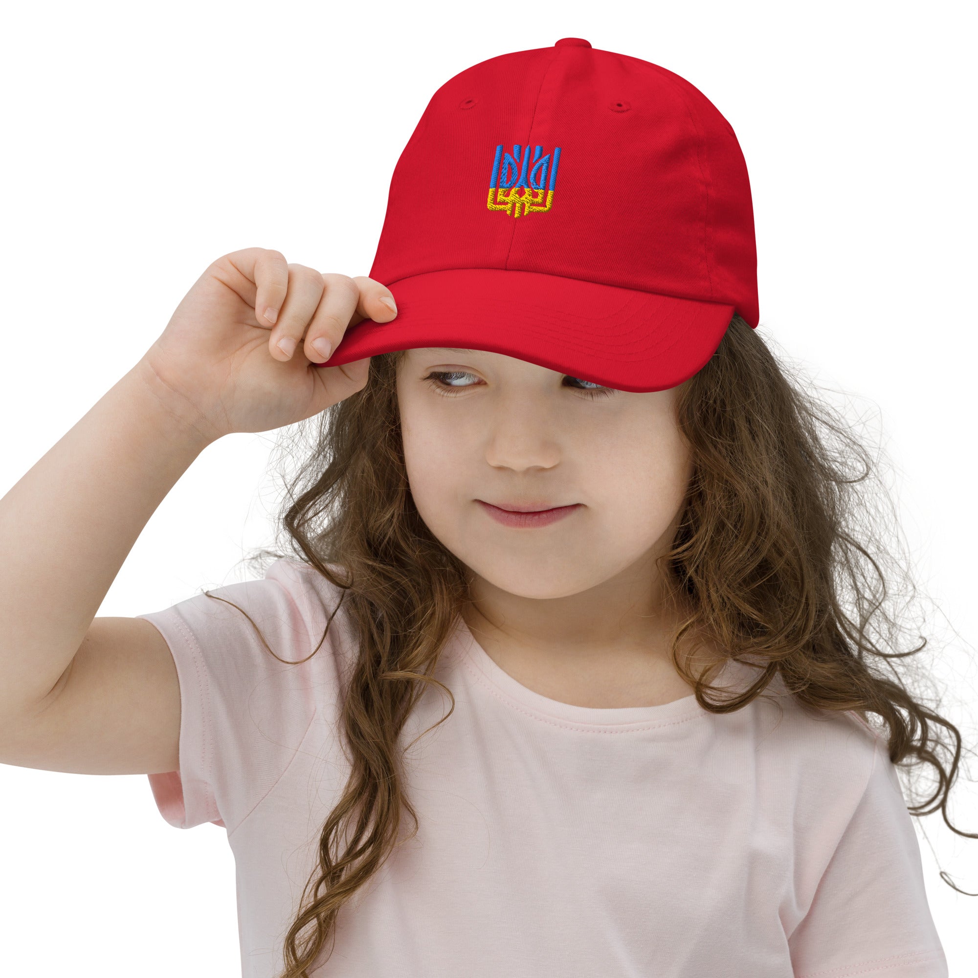 Child wearing a red youth baseball cap with Ukrainian Tryzub emblem, featuring adjustable strap and breathable design for active wear.