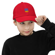 Child wearing a red youth baseball cap with Ukrainian Tryzub emblem, ideal for active kids with a breathable and adjustable design.