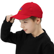 Child wearing a red youth baseball cap with Ukrainian Tryzub, adjusting brim. Perfect for active kids, breathable and adjustable.