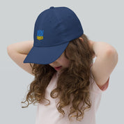 Young girl wearing a navy youth baseball cap with Ukrainian Tryzub emblem, showcasing breathable and adjustable design for active kids.