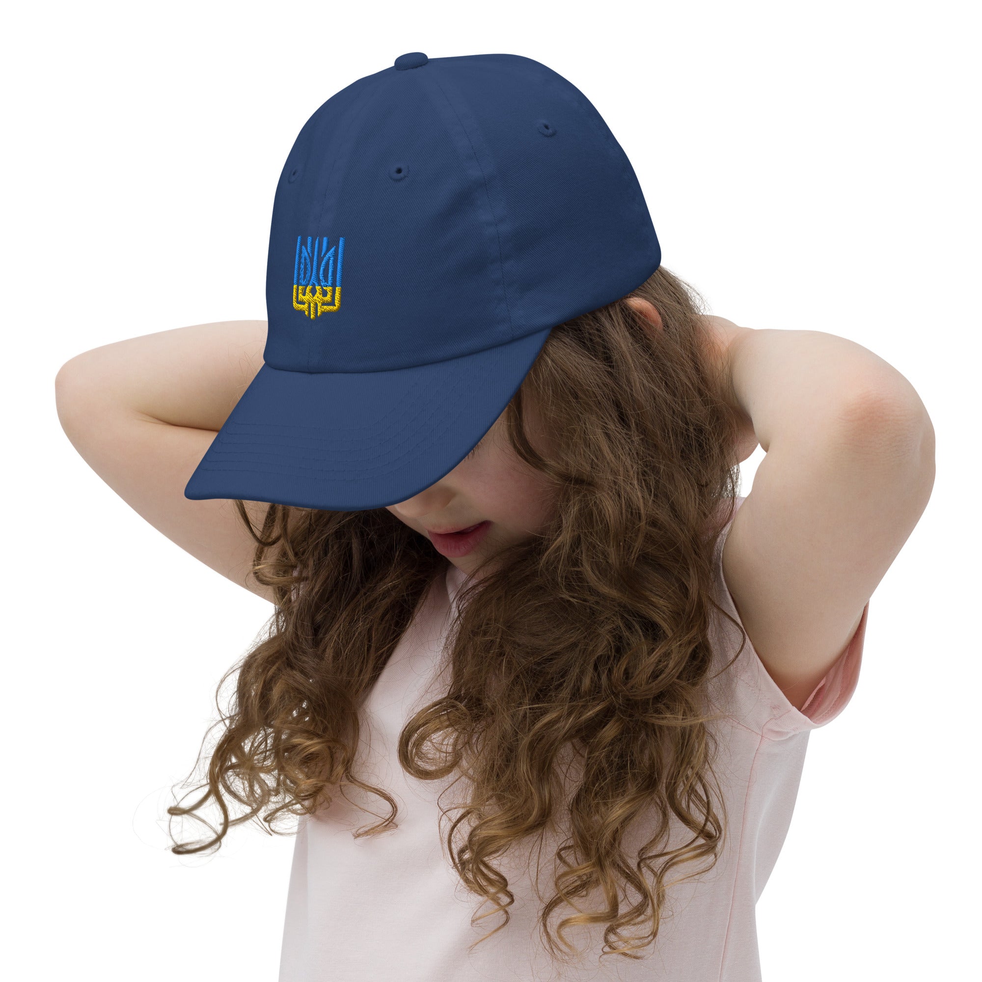 Young girl wearing navy baseball cap with Ukrainian Tryzub emblem, perfect for active kids. Breathable, adjustable, and stylish.