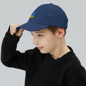 Child wearing blue youth baseball cap with Ukrainian Tryzub emblem, perfect for active kids. Made from breathable, adjustable cotton twill.