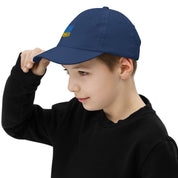 Child wearing a navy youth baseball cap with Ukrainian Tryzub emblem, perfect for sports and outdoor activities. Adjustable and breathable design.