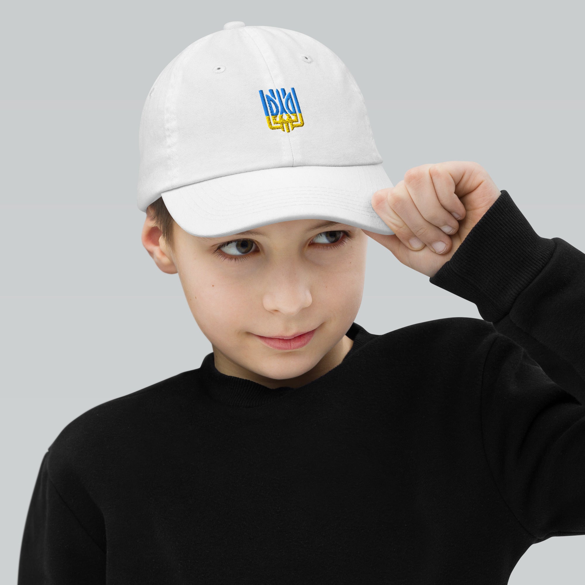 Child wearing a youth baseball cap featuring a Ukrainian Tryzub emblem, perfect for sports and outdoor adventures, with adjustable strap.