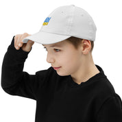 Child wearing a white youth baseball cap with Ukrainian Tryzub design, ideal for active kids, featuring breathable cotton and adjustable fit.