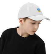 Youth baseball cap with Ukrainian Tryzub emblem, worn by child; breathable, adjustable fit for sports and outdoor activities.