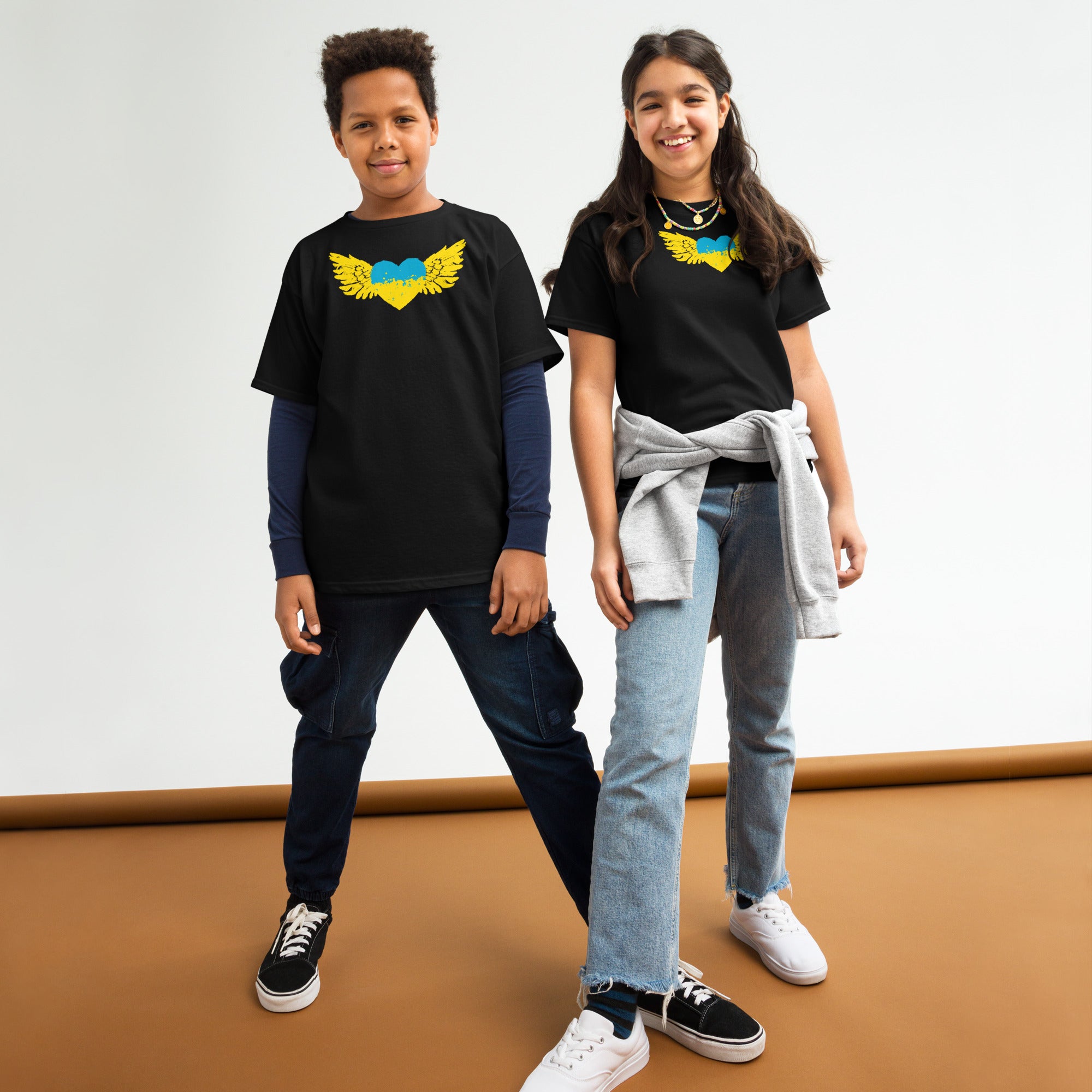 Kids wearing Youth Classic T-Shirts featuring Ukrainian Tryzub emblem in blue and gold, symbolizing Ukrainian pride and culture.