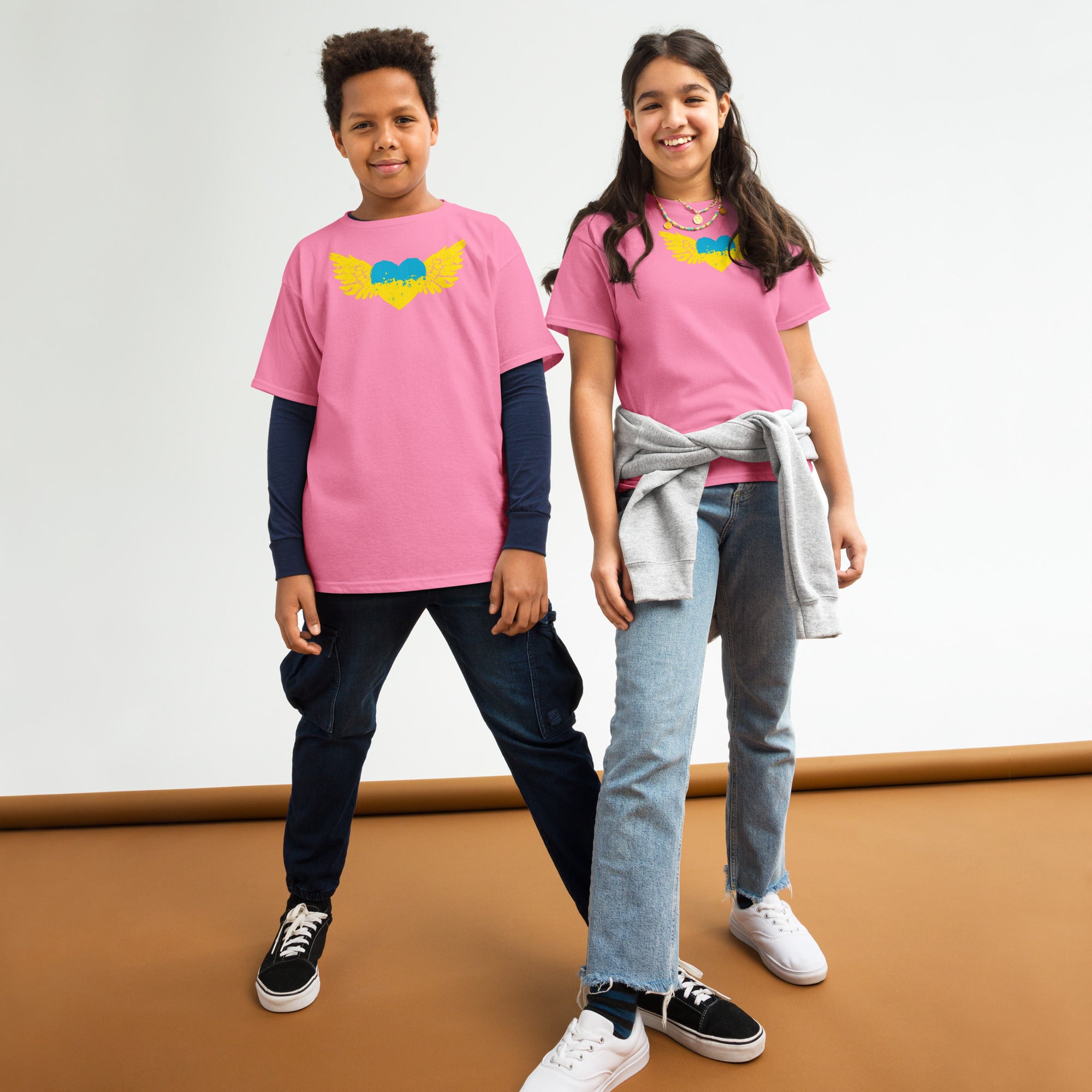 Youth wearing pink t-shirts with Ukrainian emblem Tryzub, showcasing cultural pride and comfort.
