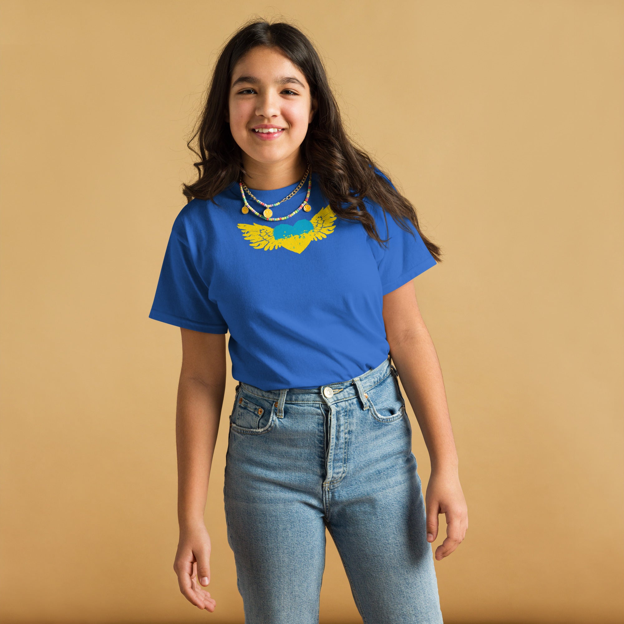 Youth wearing a blue t-shirt with Ukrainian Tryzub emblem, showing cultural pride and heritage, made of comfortable cotton fabric.