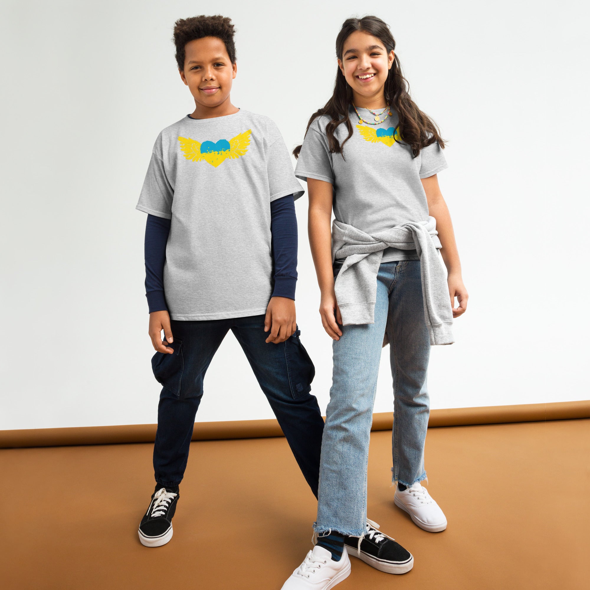 Two kids wearing youth t-shirts with Ukrainian Tryzub emblem, showcasing heritage pride and comfort for active lifestyles.