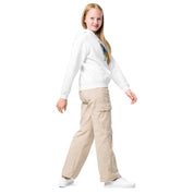 Youth in white Ukrainian superhero hoodie and khaki pants smiling on white background.