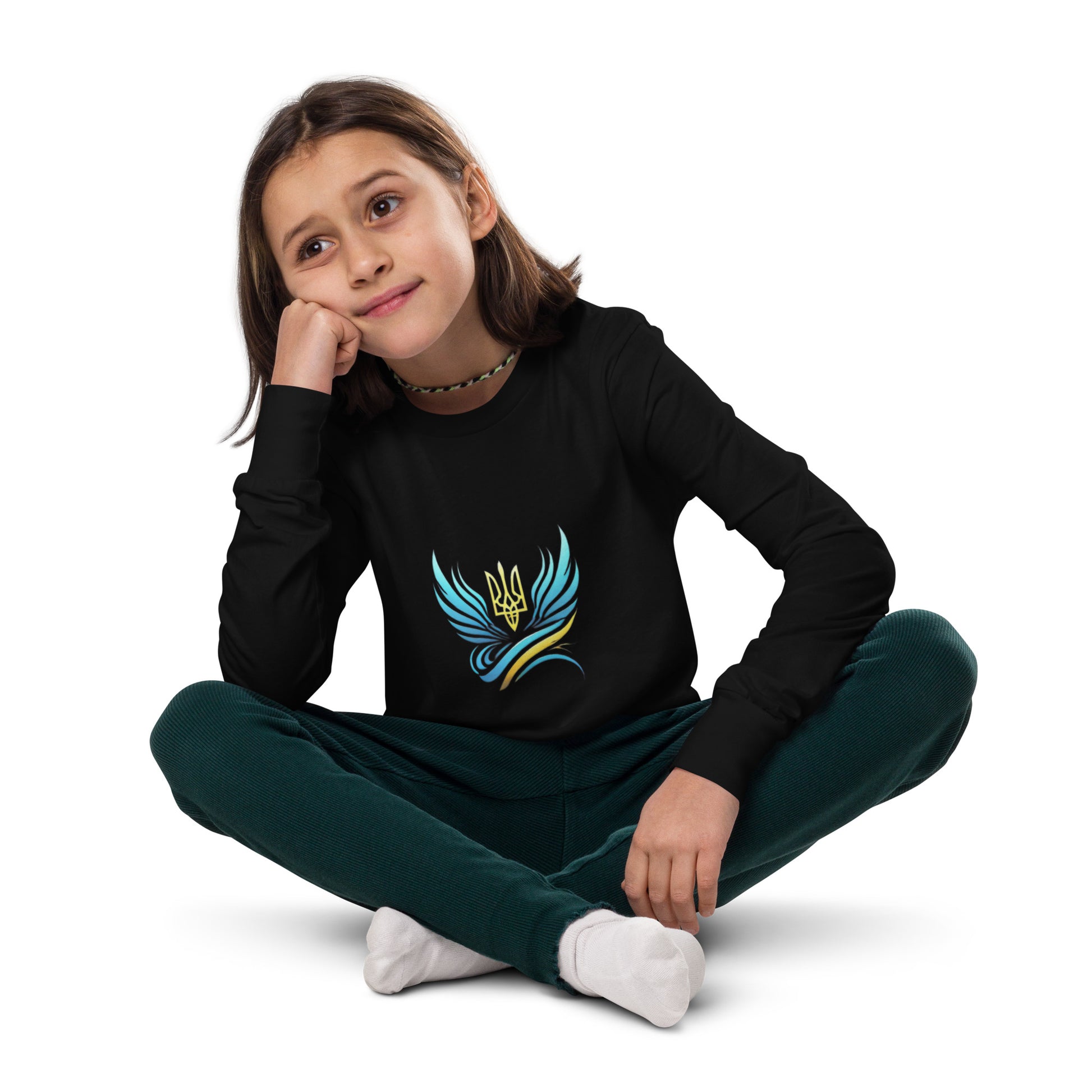 Youth wearing Ukrainian Tryzub logo long sleeve tee in black, sitting cross-legged, showcasing heritage and comfort.