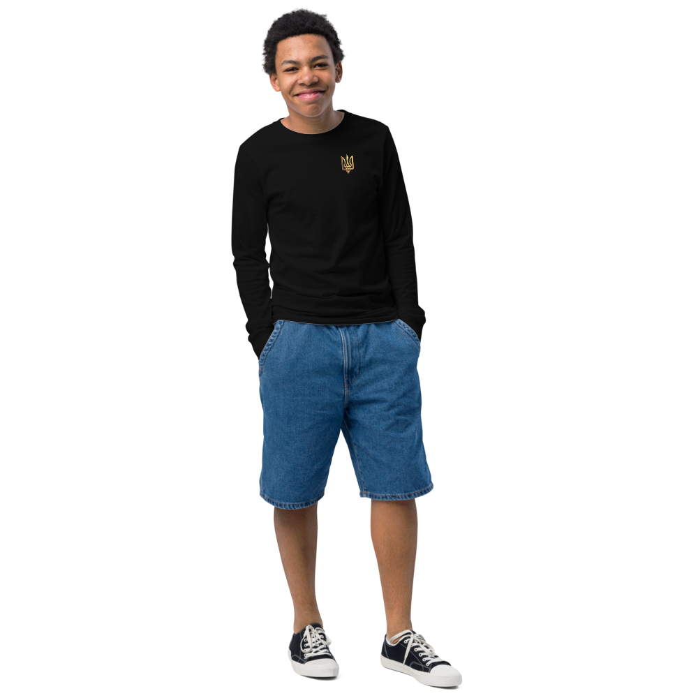 Youth wearing black long sleeve shirt with golden Ukrainian Trizub, denim shorts, and sneakers, showcasing heritage and style.