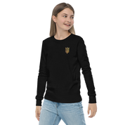 Youth wearing long sleeve shirt with golden Ukrainian Trizub on chest, celebrating heritage with style and comfort.