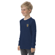Young boy wearing youth long sleeve shirt with golden Ukrainian Trizub on heart, showcasing cultural pride and style.