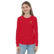 Youth in red long sleeve shirt with golden Ukrainian Trizub on heart area, showcasing heritage and style.