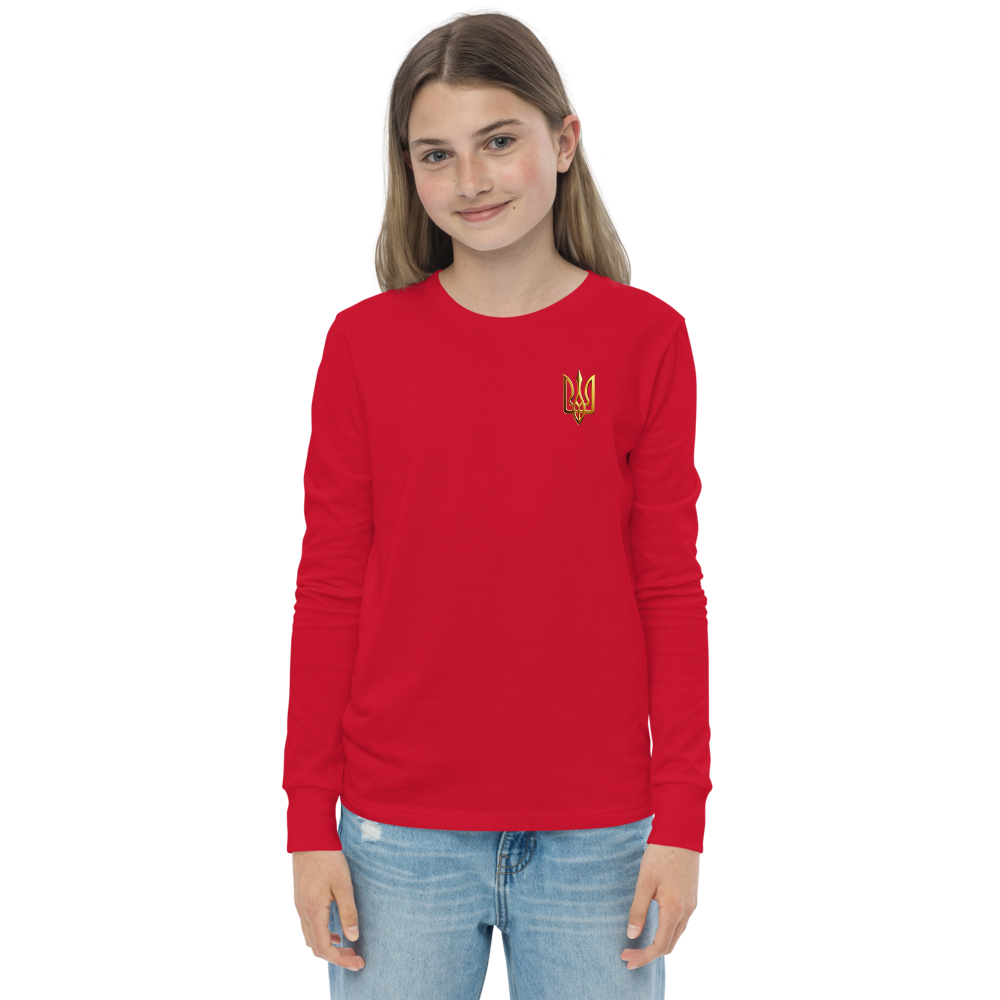 Youth long sleeve shirt with golden Ukrainian Trizub on heart, made from soft red cotton, worn by a girl.