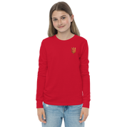 Youth long sleeve shirt with golden Ukrainian Trizub on heart, made from soft red cotton, worn by a girl.