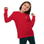 Youth wearing red long sleeve shirt with golden Ukrainian Trizub emblem on heart, showcasing heritage and style.