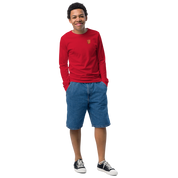 Youth wearing red long sleeve shirt featuring golden Ukrainian Trizub on heart, paired with denim shorts, showcasing cultural pride.