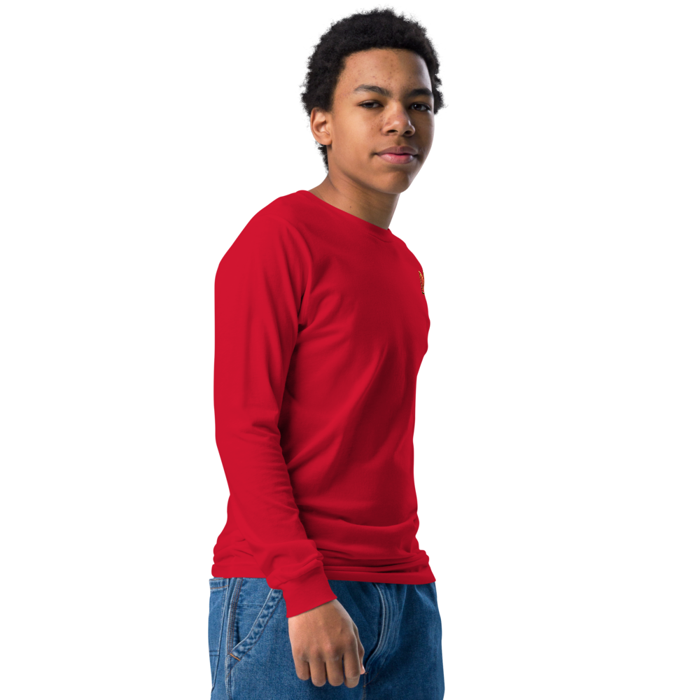 Youth wearing a red long sleeve shirt with a golden Ukrainian Trizub, showcasing heritage pride.