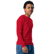 Youth wearing a red long sleeve shirt with a golden Ukrainian Trizub, showcasing heritage pride.