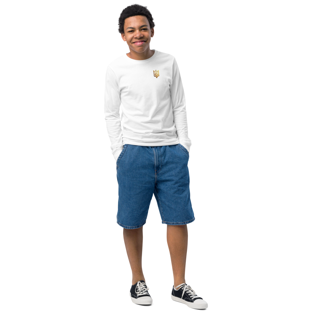 Youth wearing a white long sleeve shirt with Ukrainian Trizub on left chest, paired with denim shorts and sneakers.