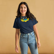 Youth wearing a navy t-shirt featuring the Ukrainian Tryzub emblem, standing against a warm background. Celebrating Ukrainian pride.
